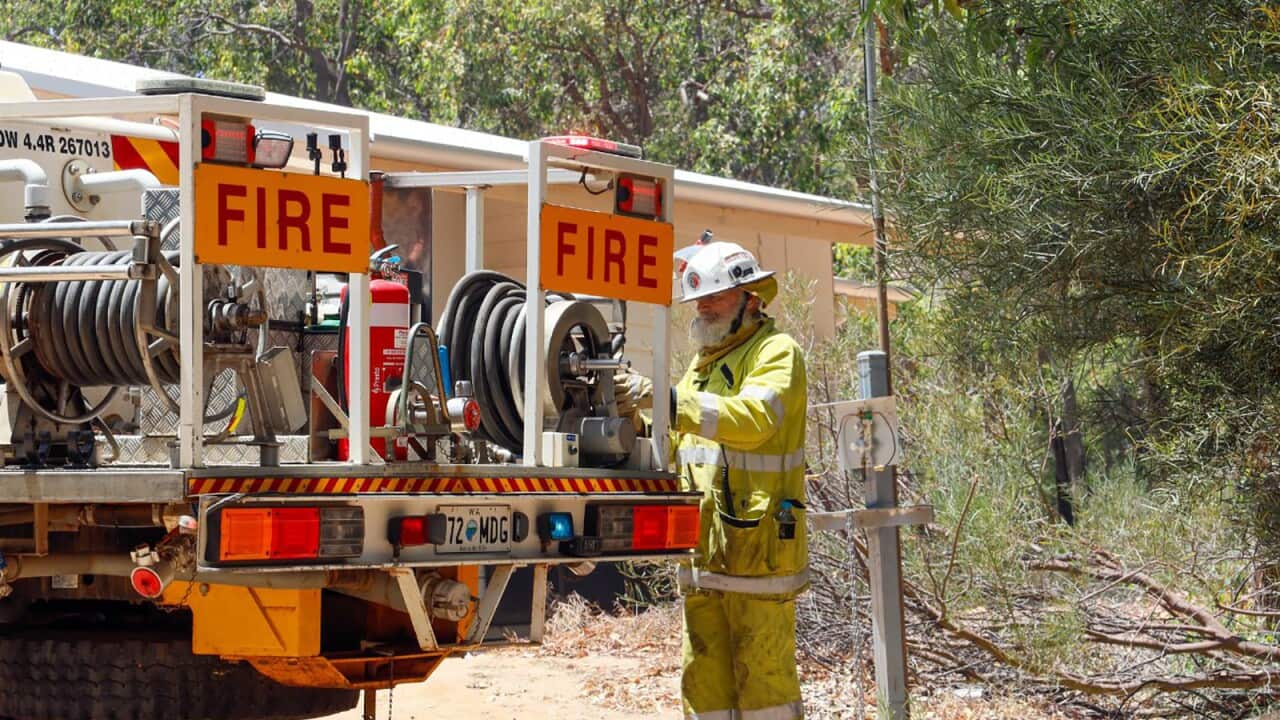 A firefighter next to a hire truck
