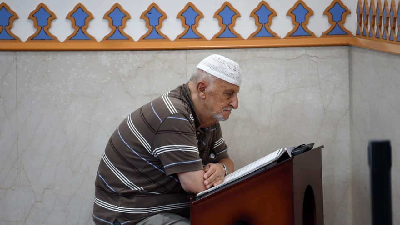 A man is seen reading after prayer at the Lakemba Mosque in south west Sydney,