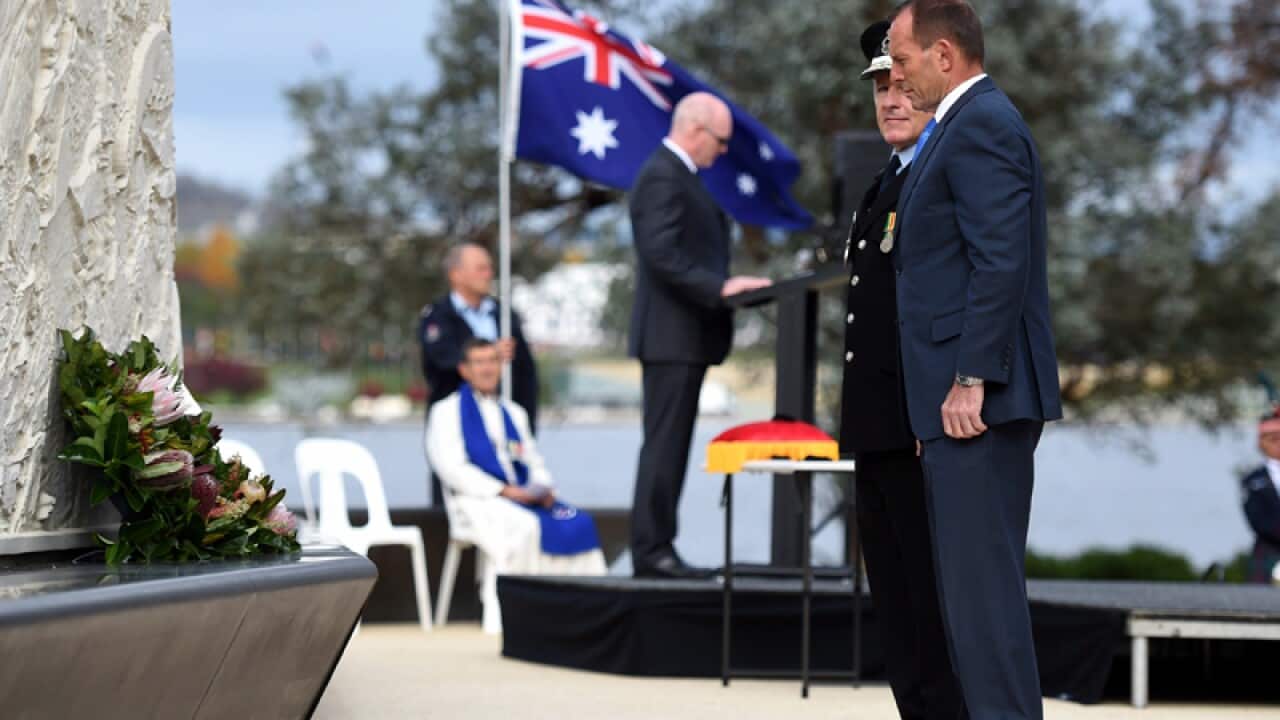 Tony Abbott lays a wreath during a service in Canberra
