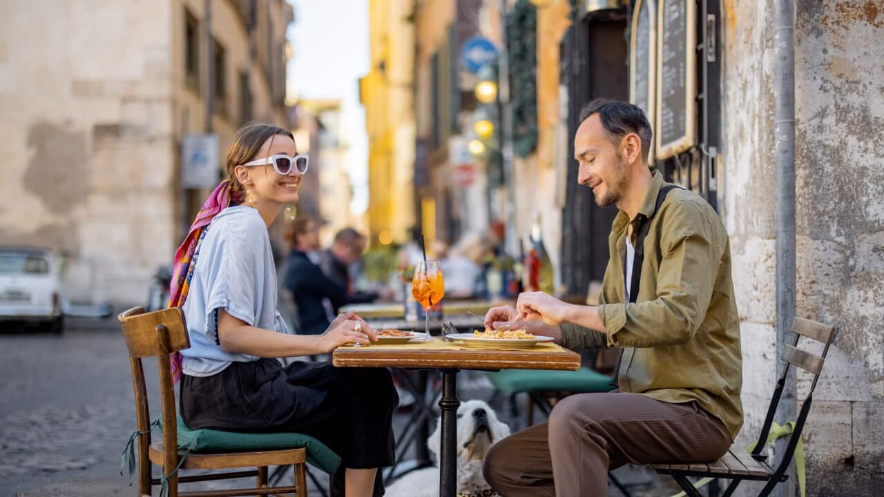 solo yachtswoman A woman and man eating at a restaurant on the street in Rome