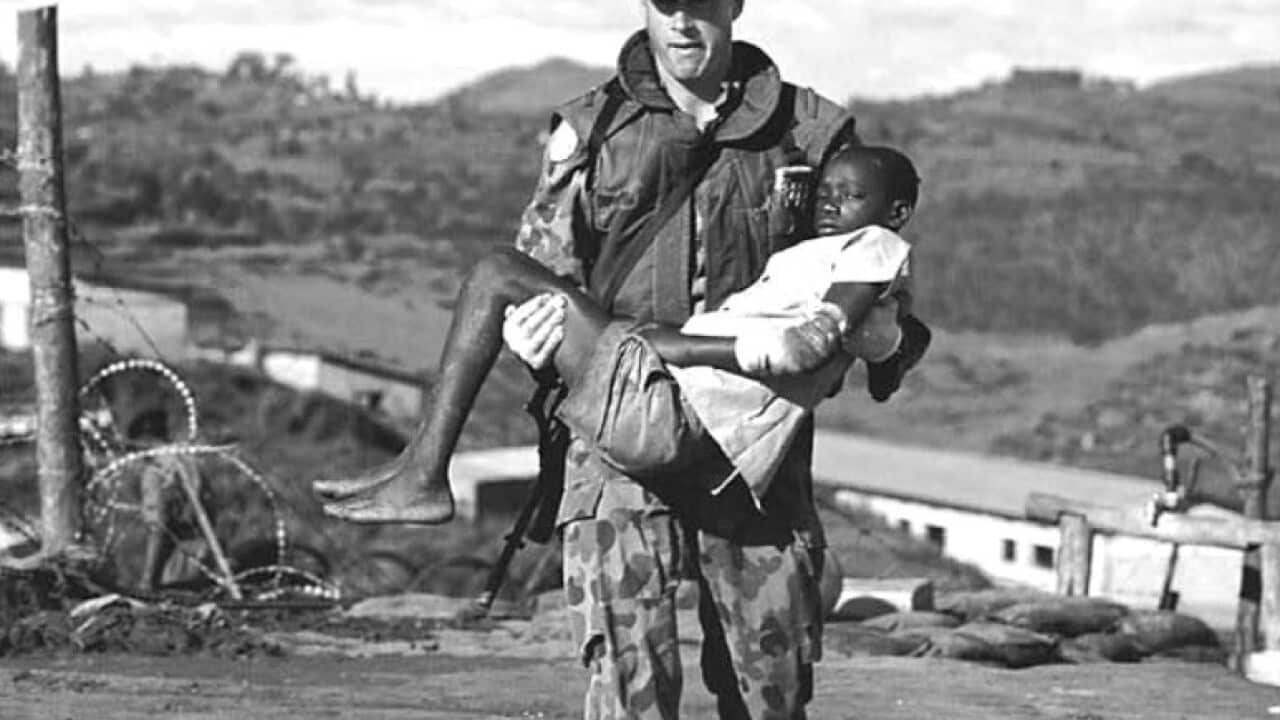 Australian soldier carrying a young Rwandan boy injured in Kibeho.