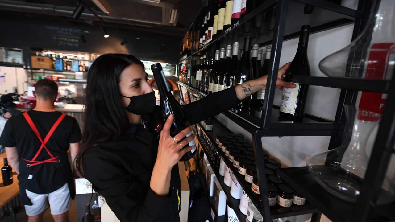 Staff member Nicoletta Alberici restocks bottles of wine at 48h Pizza and Gnocchi Bar ahead of their reopening.