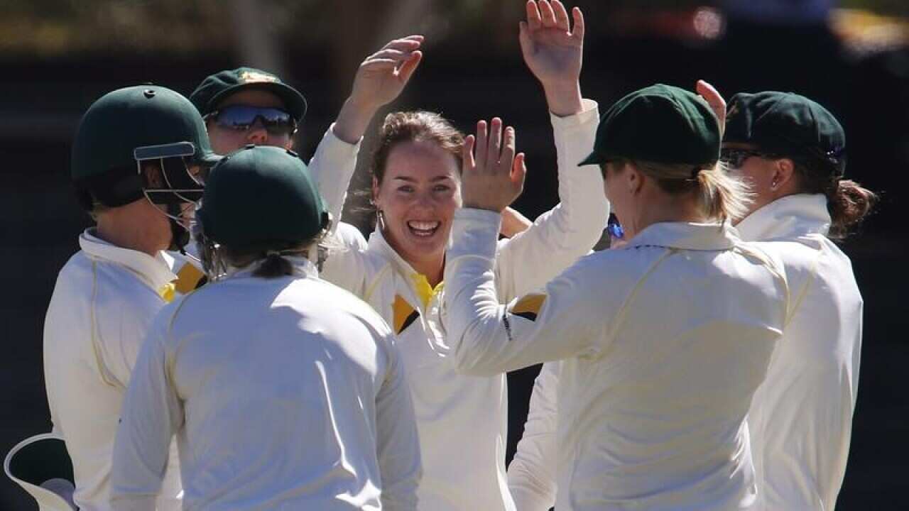 Amanda Wellington is congratulated by teammates after getting a wicket