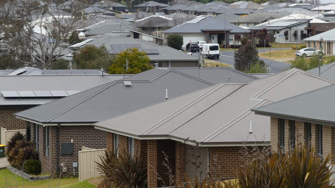 A photo of houses with grey rooves in a suburban street