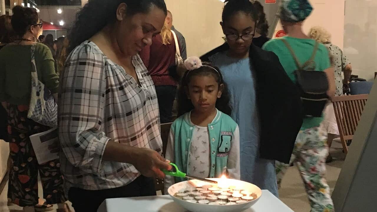 People light candles at the vigil.