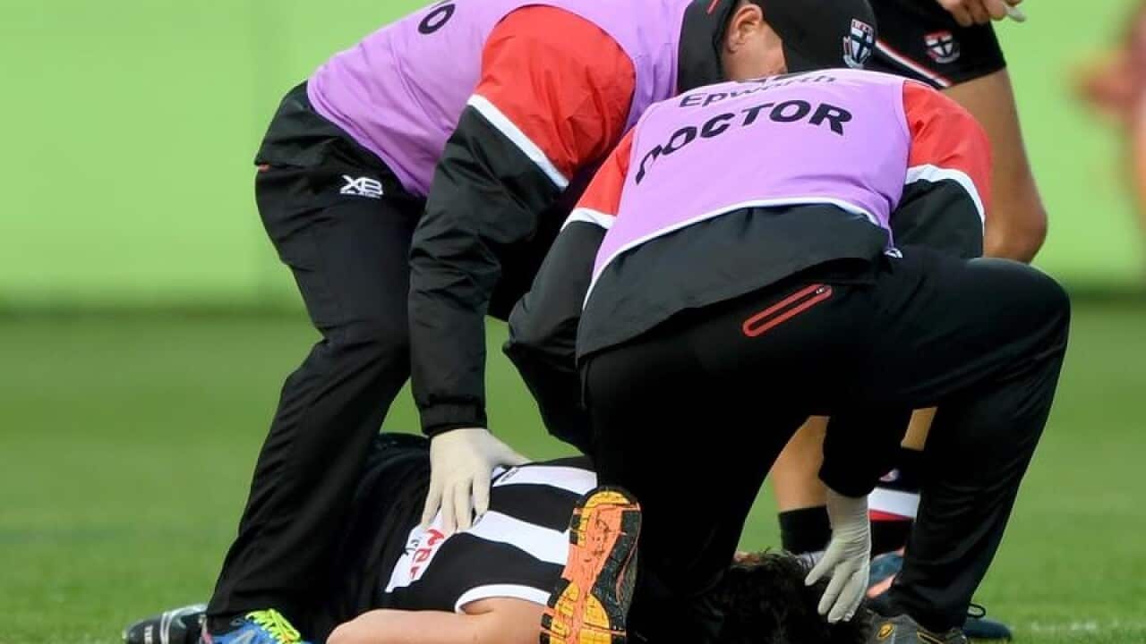 Dylan Roberton of the Saints lays on the ground after fainting.