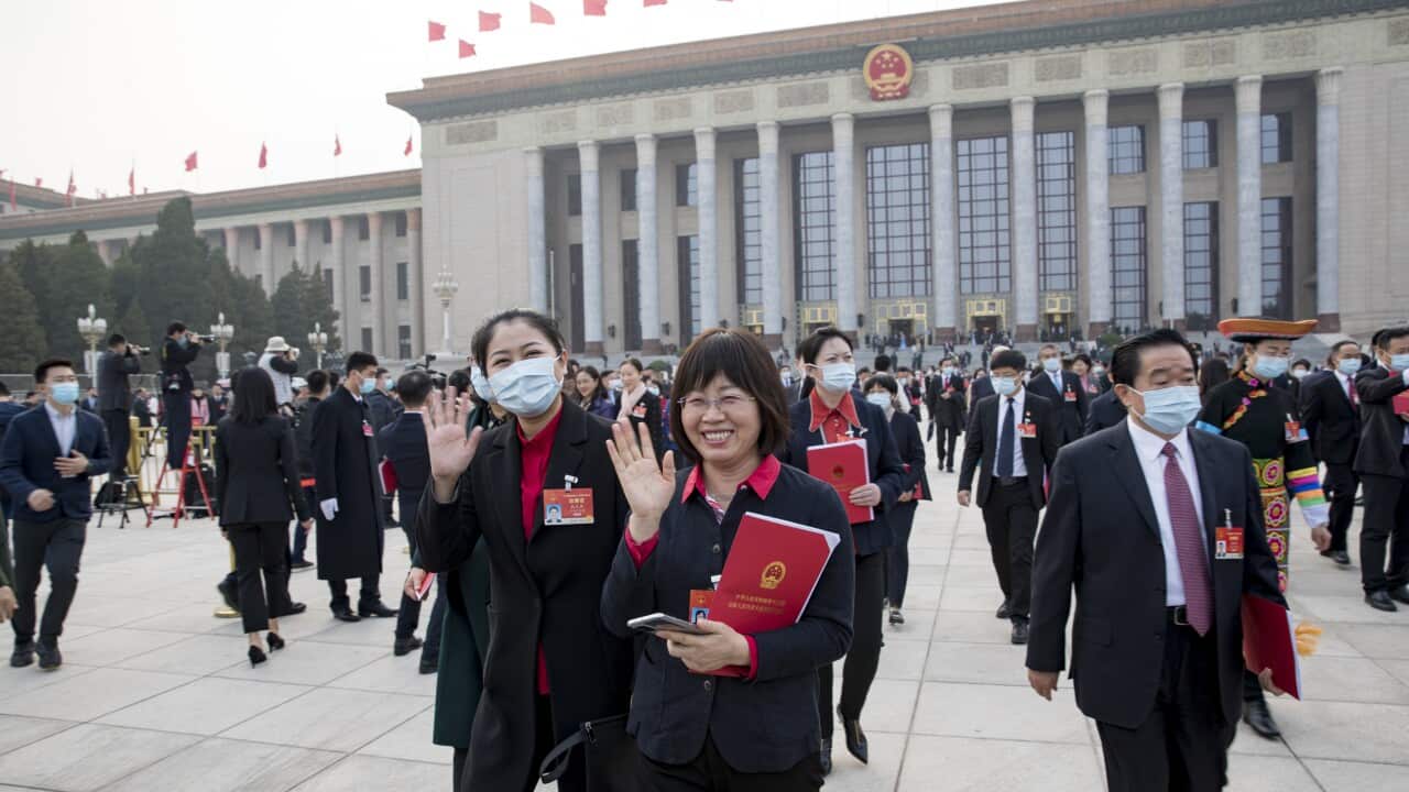 Deputies to the 13th National People's Congress walk out of the Great Hall of the People after the closing meeting.
