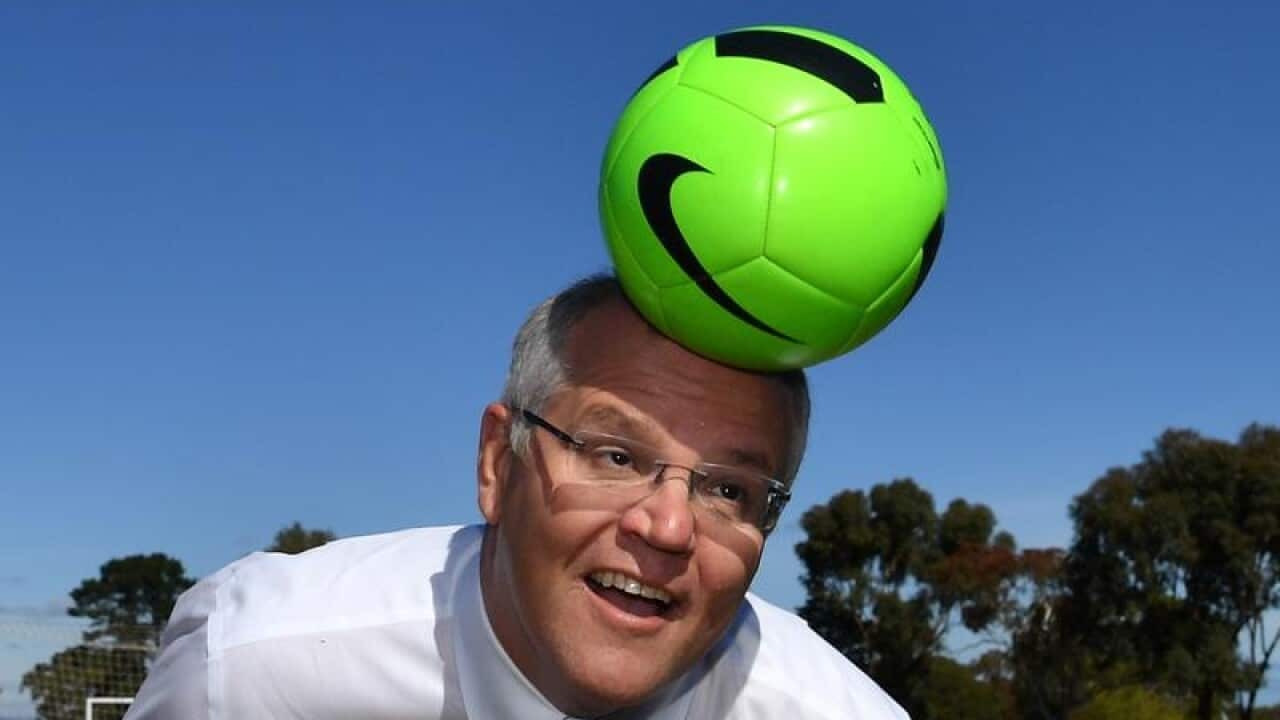 Prime Minister Scott Morrison heads a soccer ball in Adelaide.