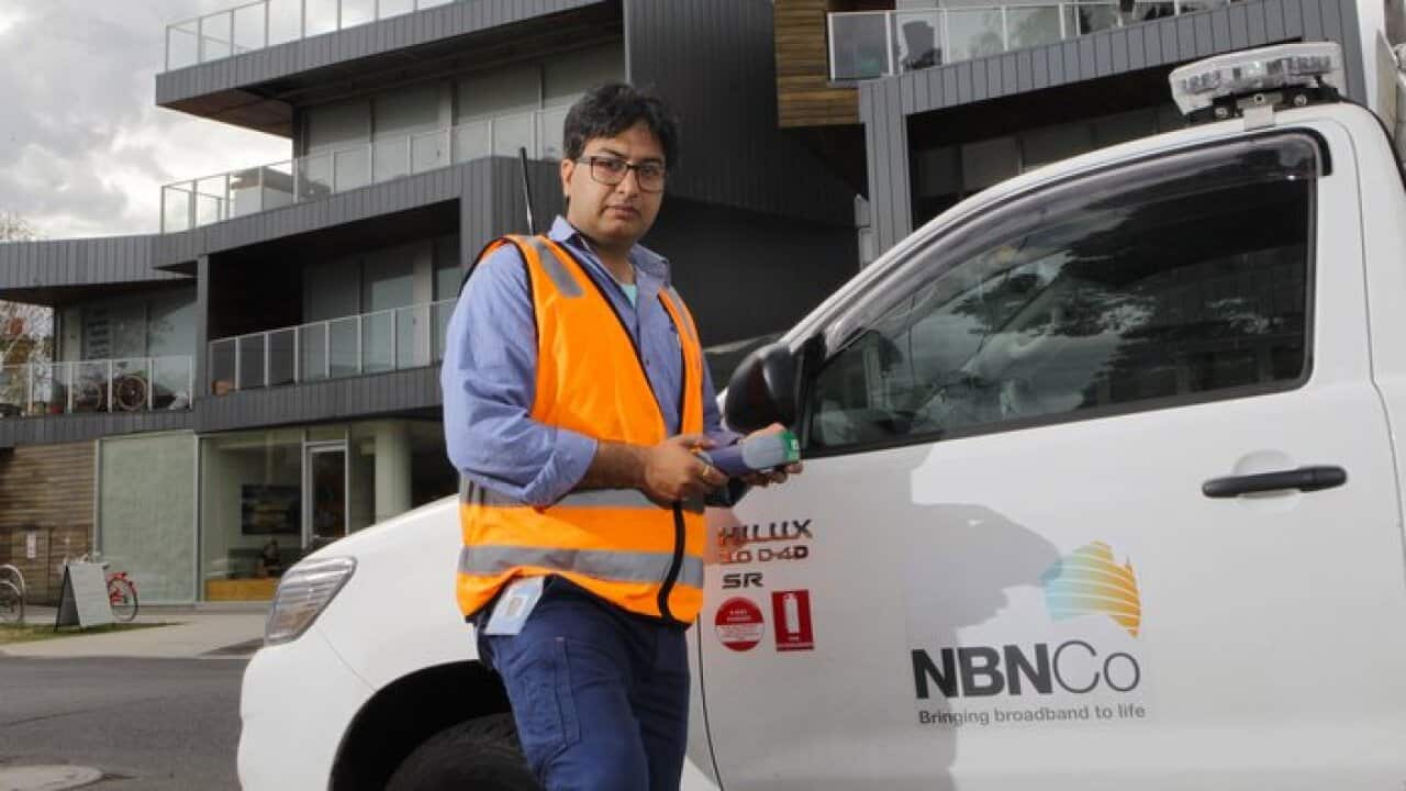 NBN technician Rajav Kapil in front of an apartment block that has been connected to the National Broadband Network (NBN) in Brunswick, Melbourne, Tuesday, March 11, 2014. (AAP Image/David Crosling) NO ARCHIVING