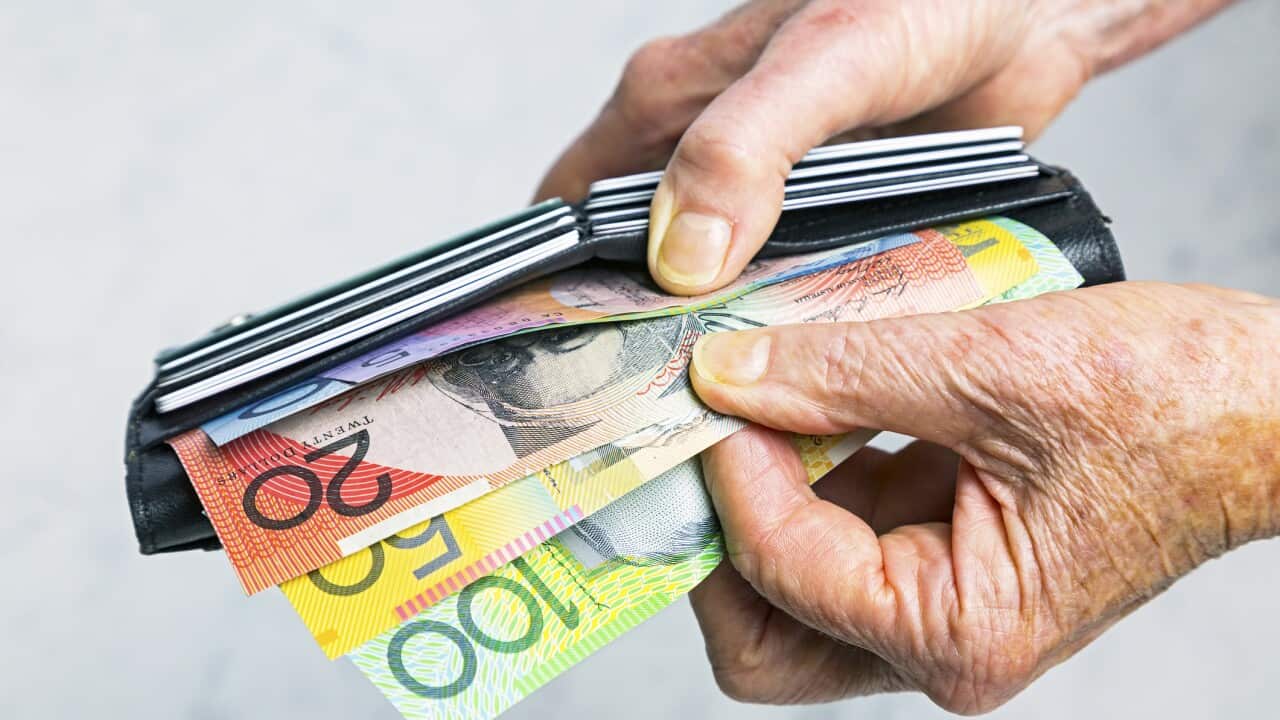 Close-up senior female hands taking Australian banknotes from purse