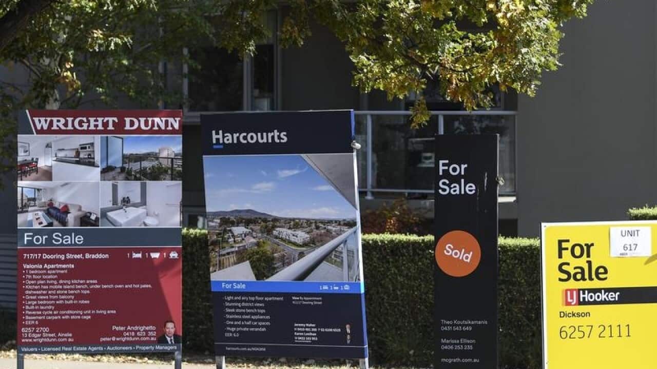 'For sale' signs are seen outside an apartment block in Canberra.