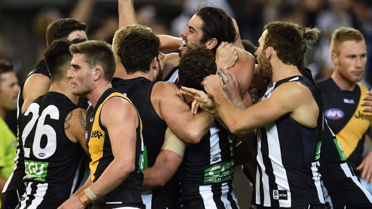 Magpies players react after Brodie Grundy (C) kicked the winning goal