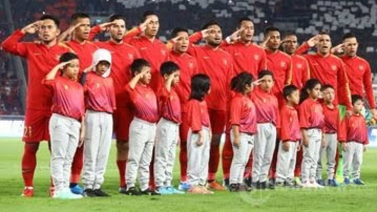 Indonesian national team players sing the national anthem before facing Malaysia in a 2022 World Cup qualifier.