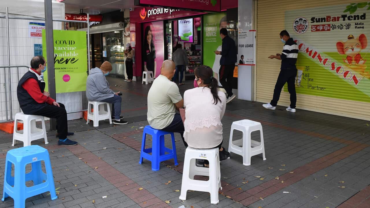 People are seen waiting to receive a Covid vaccination at a pharmacy in Cabramatta, SW Sydney.