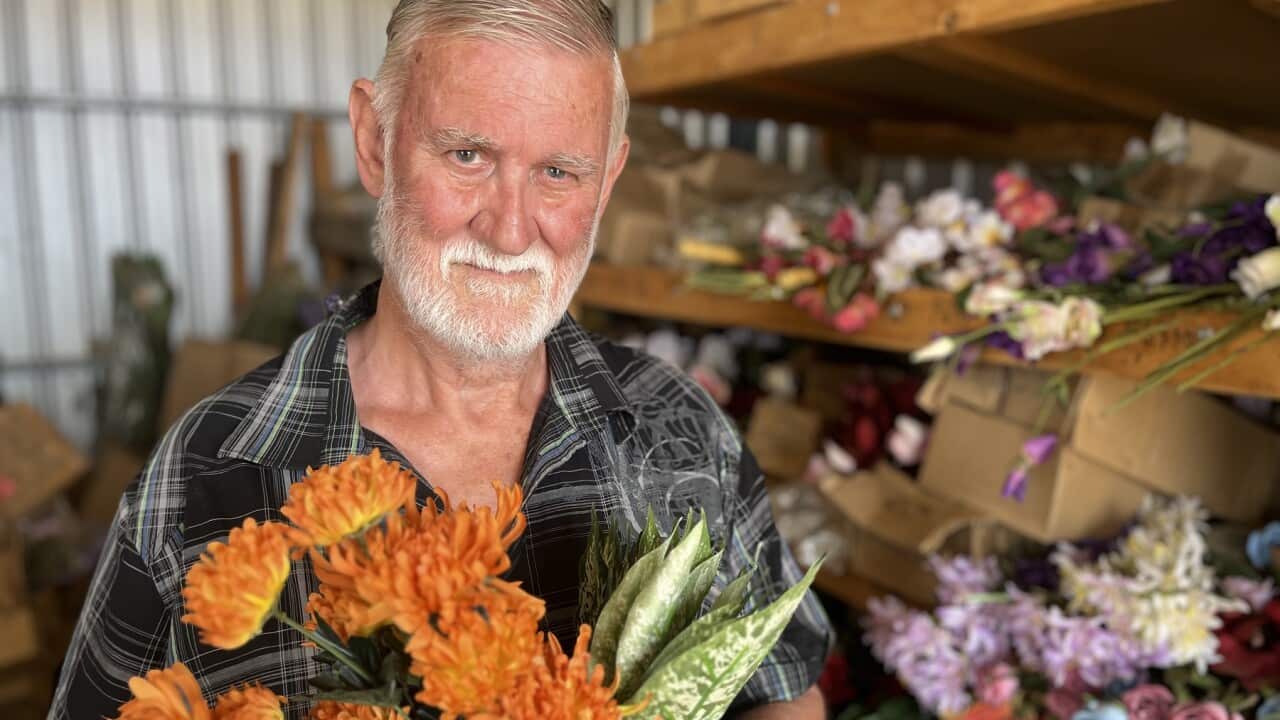 Richard Byers holding artificial flowers which he sells for his gardening business.