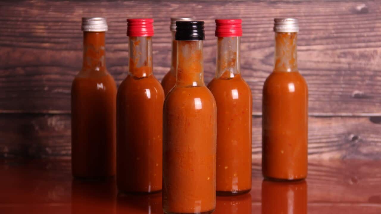 Hot sauce bottles on a red table