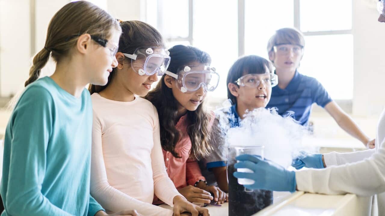 A teacher showing a scientific experiment to students