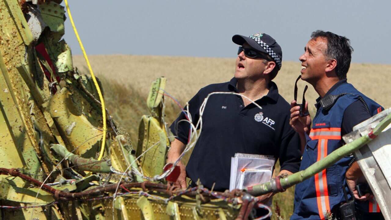 AFP personnel inspect the MH17 crash site
