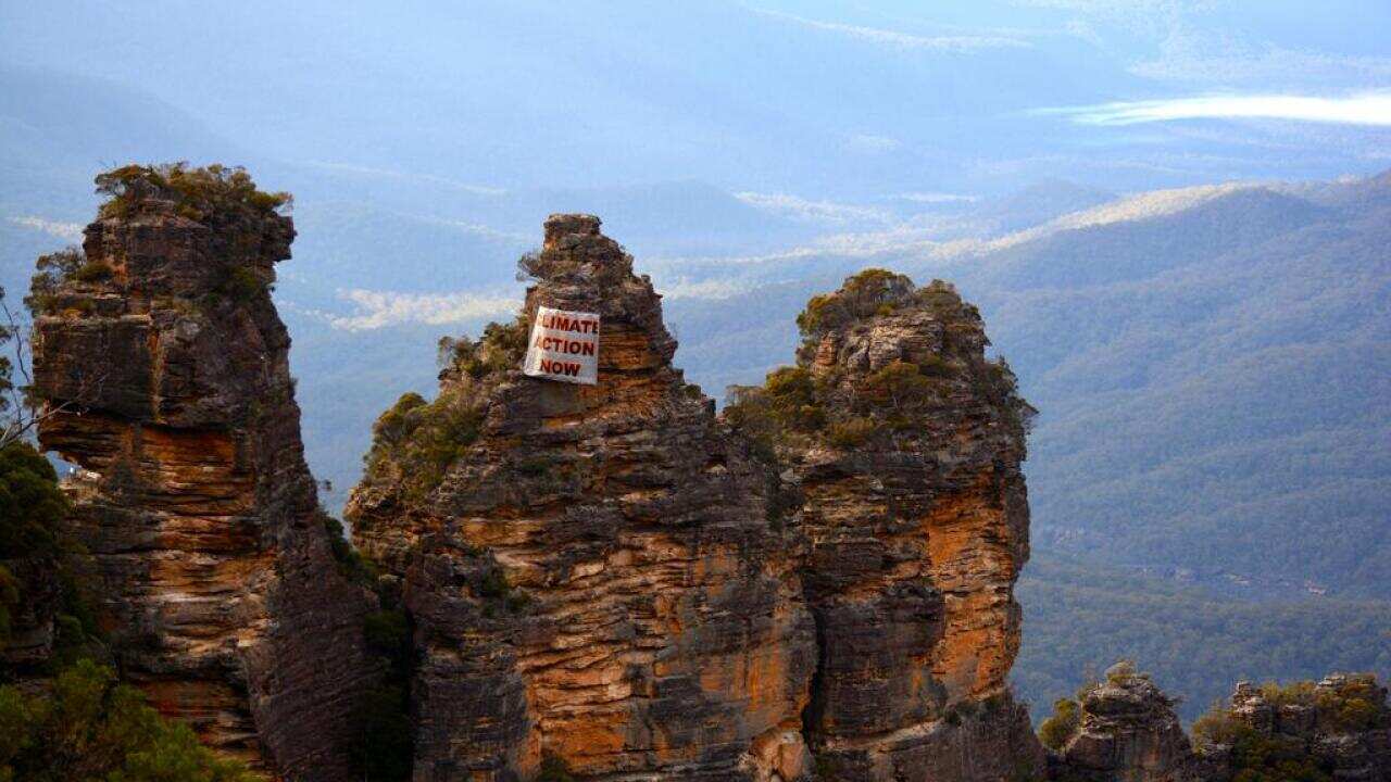 Three Sisters pictured with protest poster 