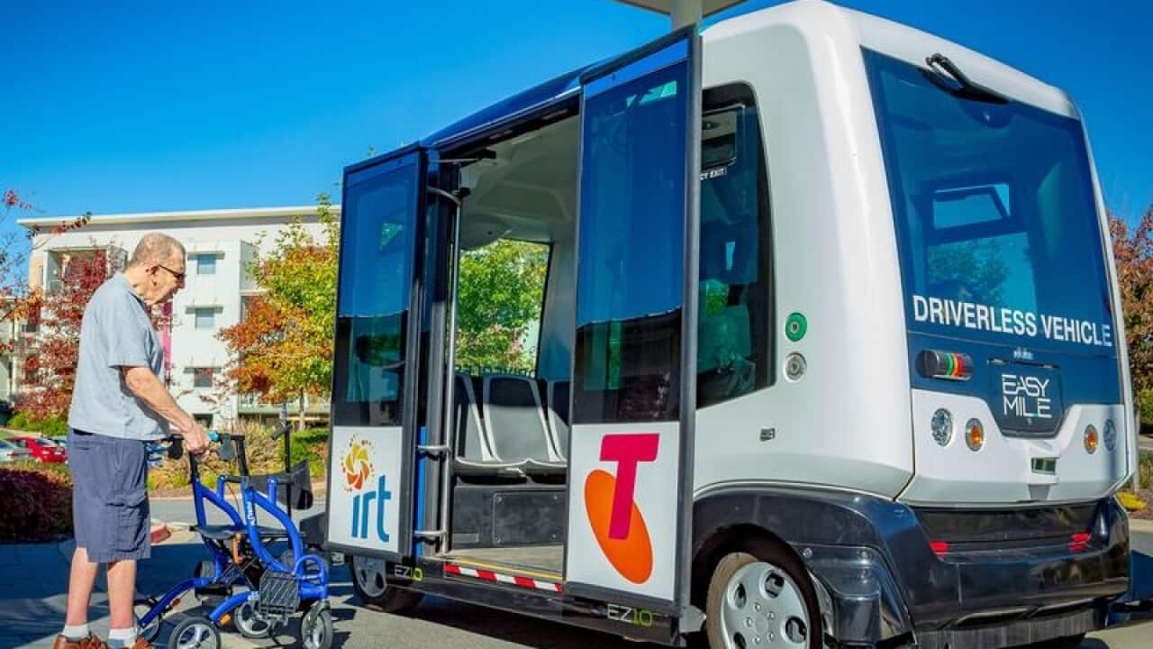 An elderly man boarding a driverless bus.