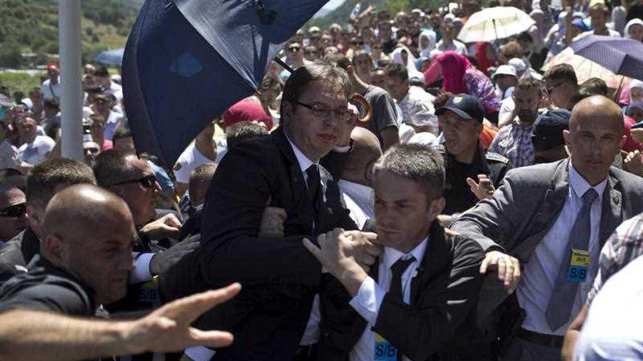 Aleksandar Vucic, Serbia's prime minister, center, is seen during a scuffle at the Potocari memorial complex near Srebrenica