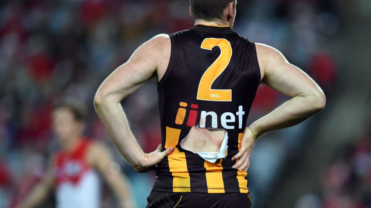 Jarryd Roughead of the Hawks with his torn jersey