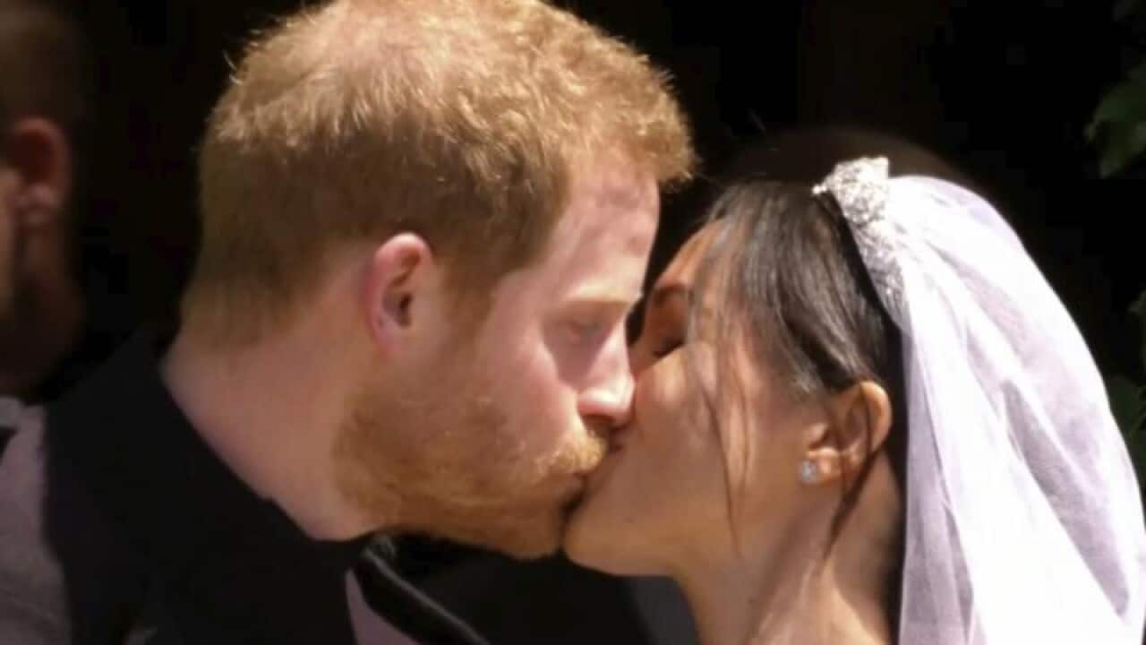 Prince Harry and Meghan Markle kiss outside after the wedding.