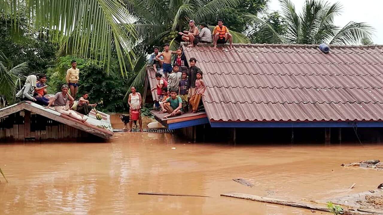 Lao villagers are seen stranded on rooftops of houses to evacuate from floodwaters after the dam collapse. 