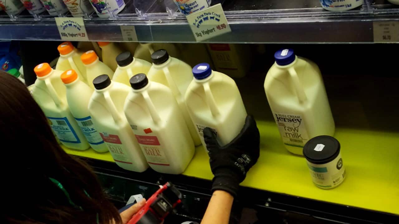 Staff at a health food store restocking bath milk