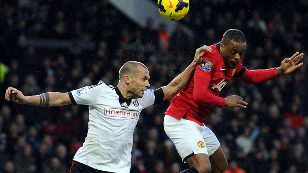 John Heitinga (L) and Patrice Evra compete for the ball