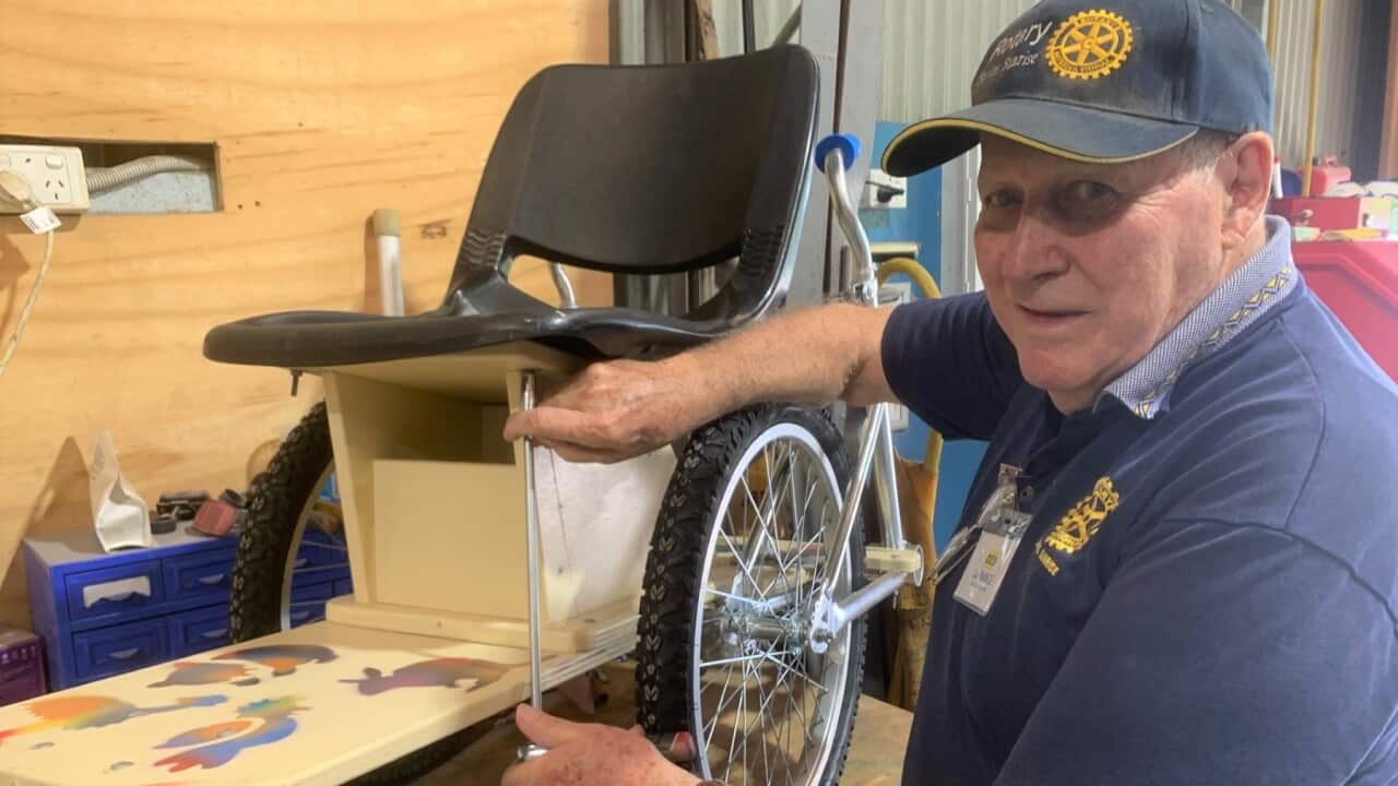 Inventor Des La Rance with a wheelchair made from repurposed bicycles.