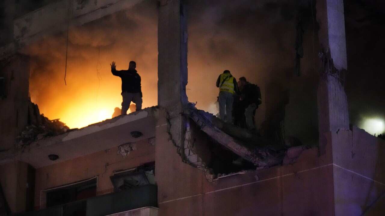 Civil defense workers search for survivors inside an apartment following a massive explosion in the southern suburb of Beirut, Lebanon, Tuesday, Jan. 2, 2024