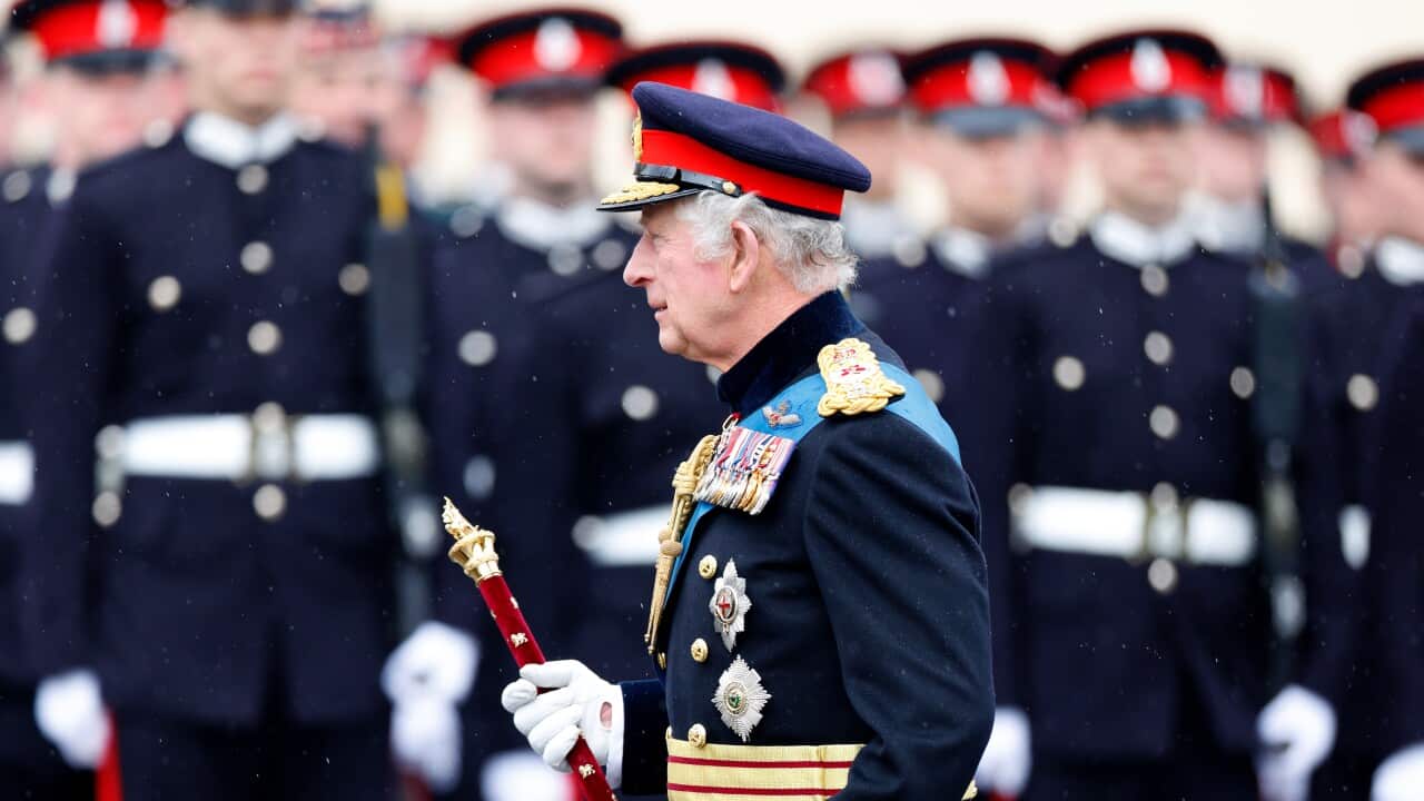 King Charles inspects soldiers at a military event.