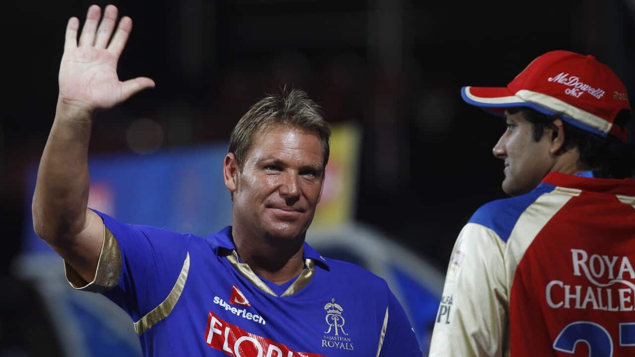 Rajasthan Royals captain Shane Warne, left, waves to his fans as rains delay the play of an Indian Premier League (IPL) cricket match.