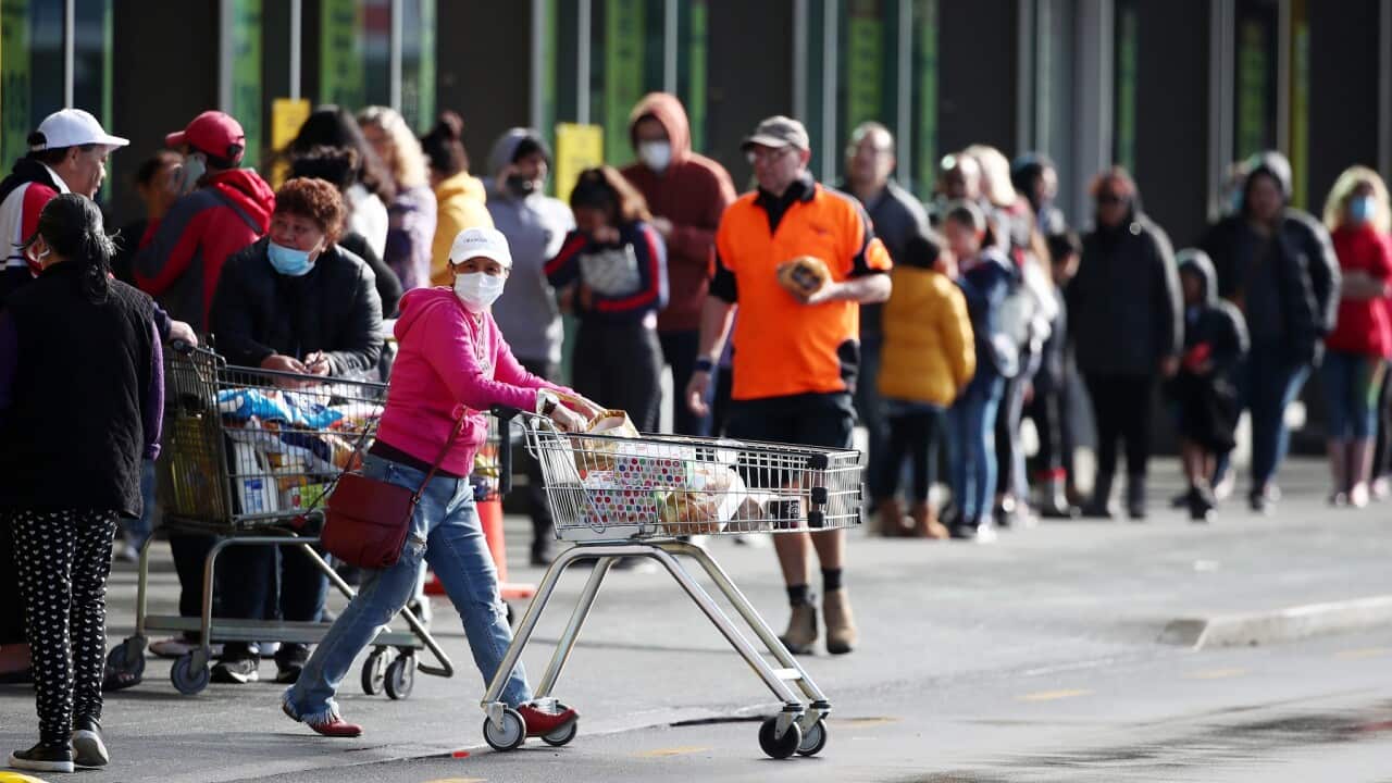 People queue outside a supermarket in west Auckland, NZ