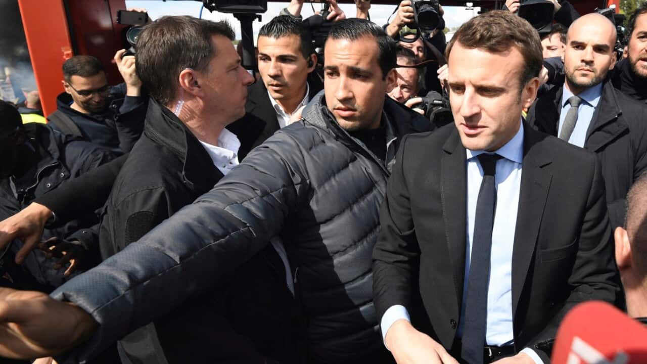 In this Wednesday April 26, 2017 file photo French centrist presidential election candidate Emmanuel Macron, flanked by his bodyguard, Alexandre Benalla.