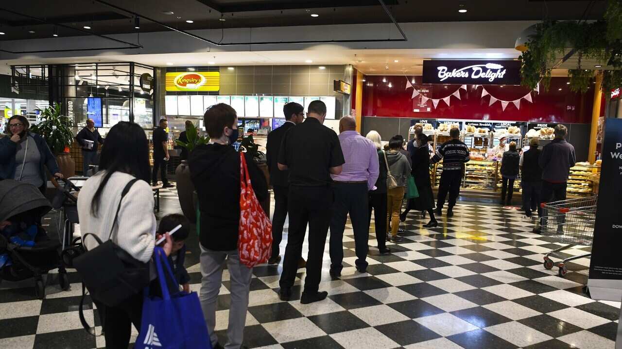 Customers queue at a bakery in Woden, Canberra following the lockdown announcement (AAP)
