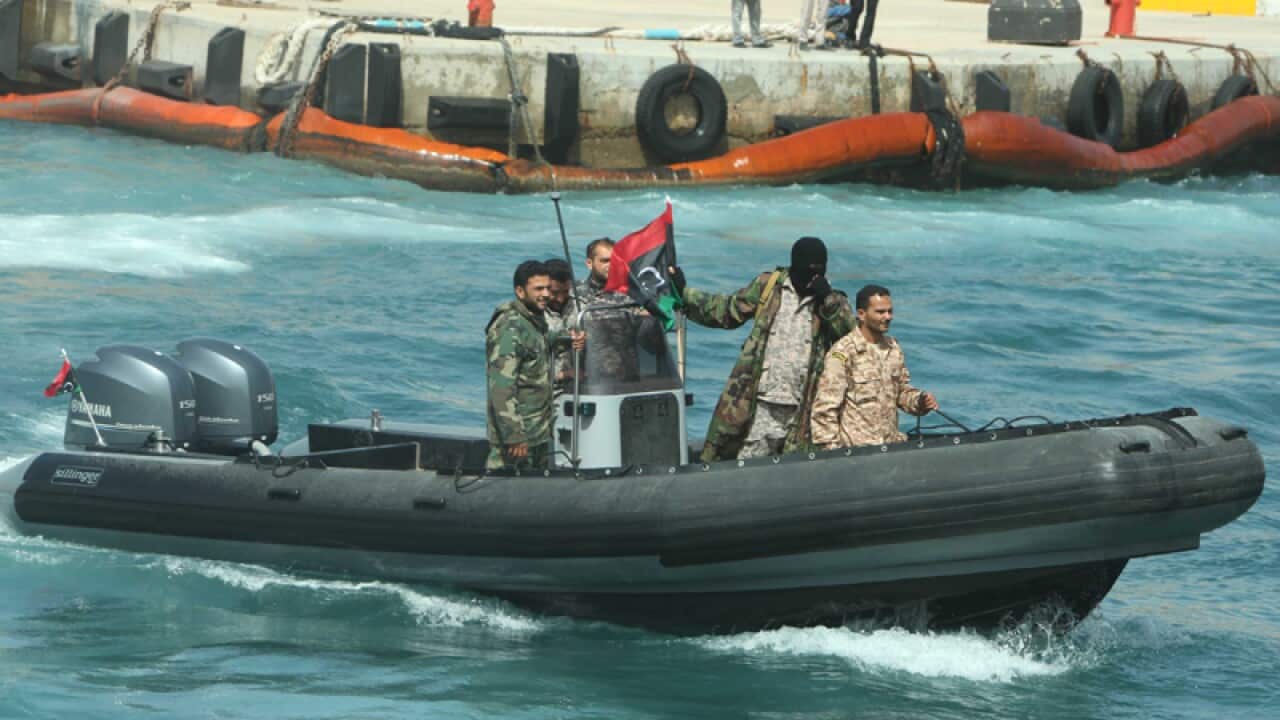 Members of Libya's naval coastguard wait for the arrival of a tanker
