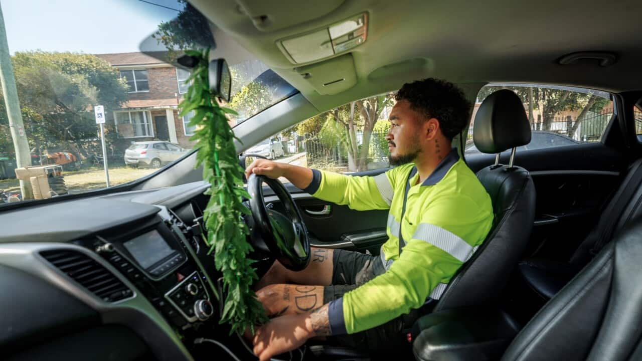Young delivery worker with reflective clothes driving car