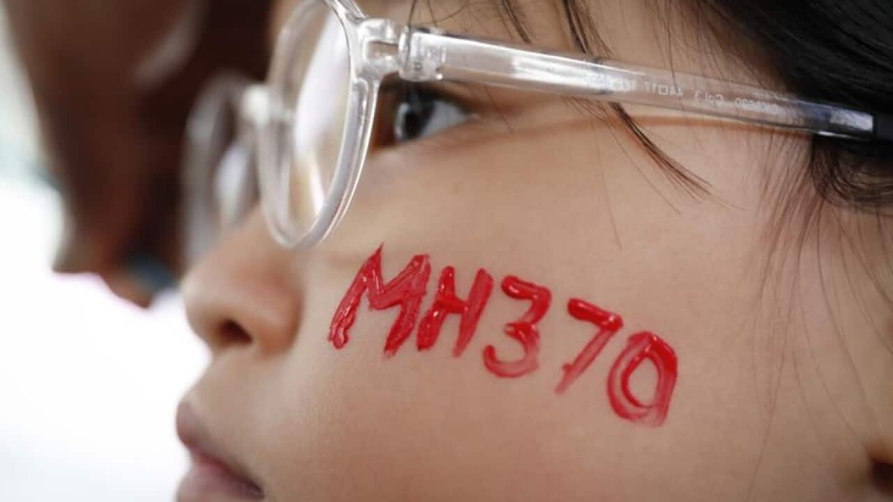 A girl with MH370 painted on her face at a remembrance ceremony