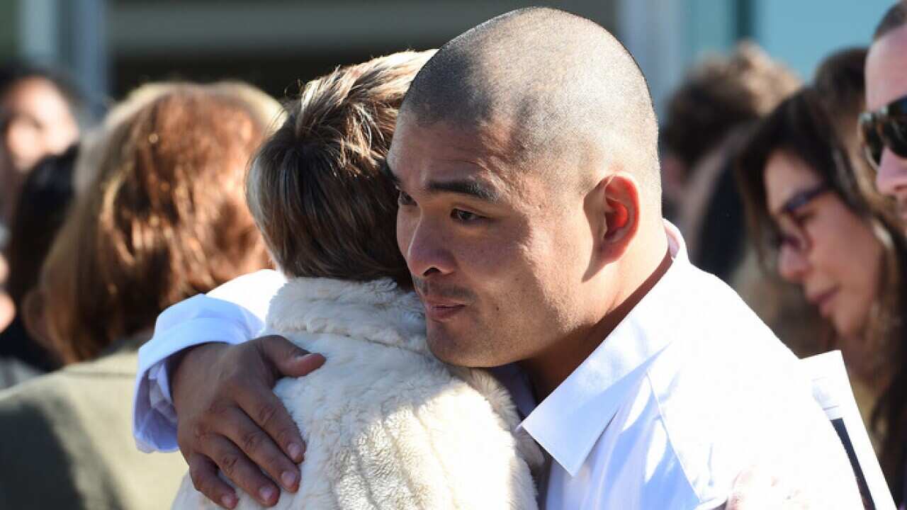 Michael Chan is comforted at the Sydney funeral service for his executed brother, Andrew Chan