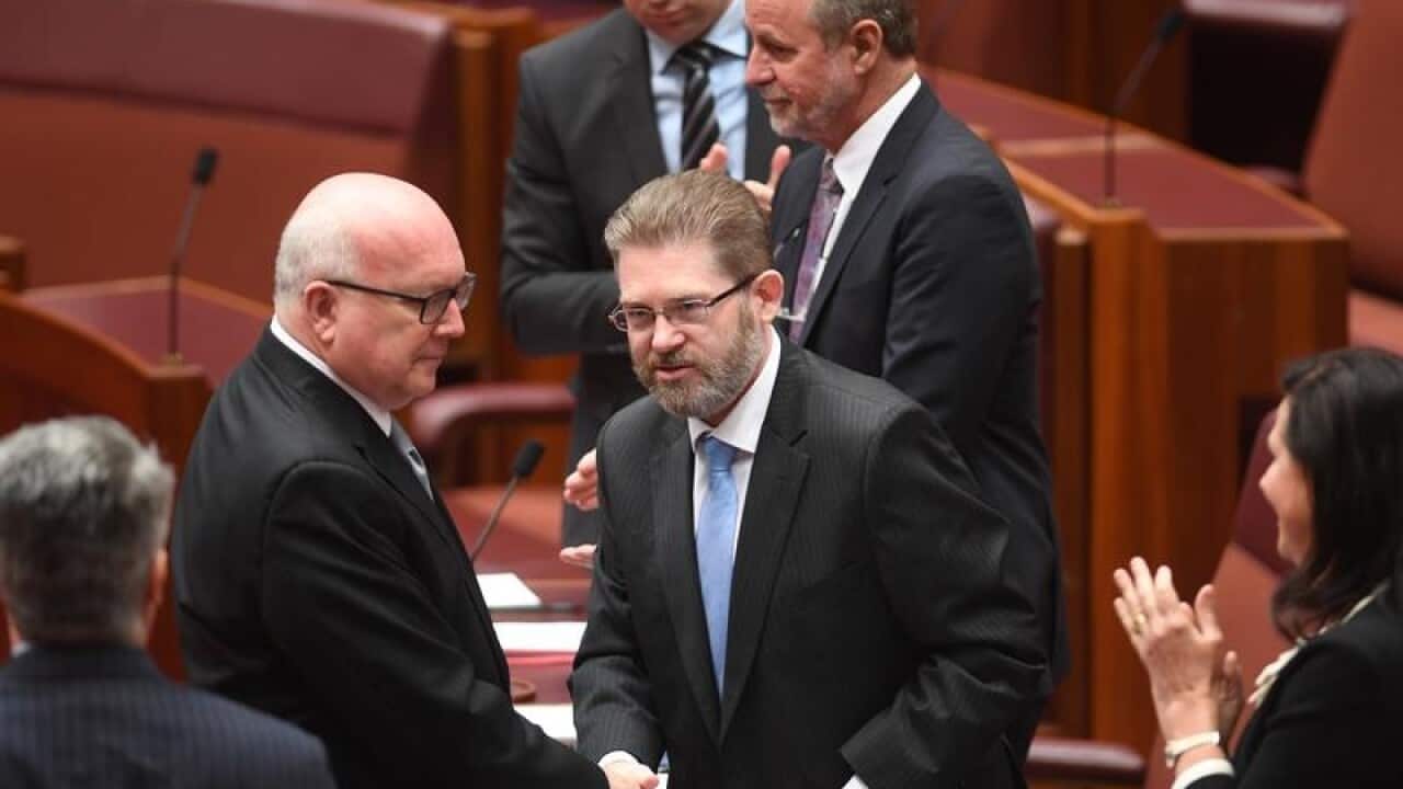 Senators congratulate each other after new senators join the chamber.