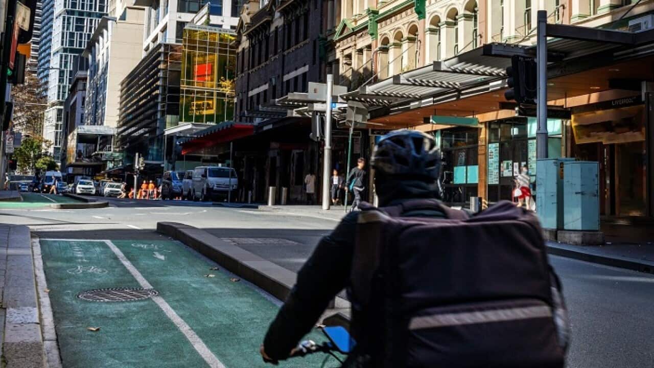 Food delivery bike driver cycling in bike lane in Sydney city