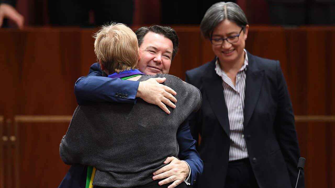 Australian Greens Senator Janet Rice (left) receives a hug from Liberal Senator Dean Smith after speaking on The Marriage Amendment Bill.