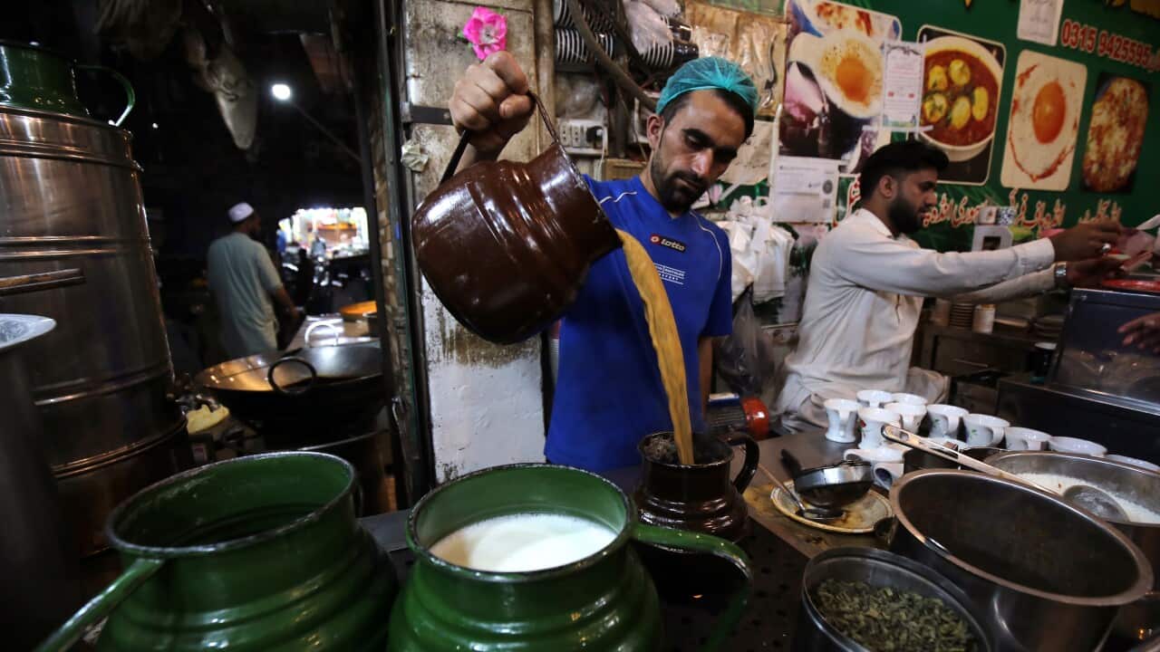 A man pours tea in a large flask