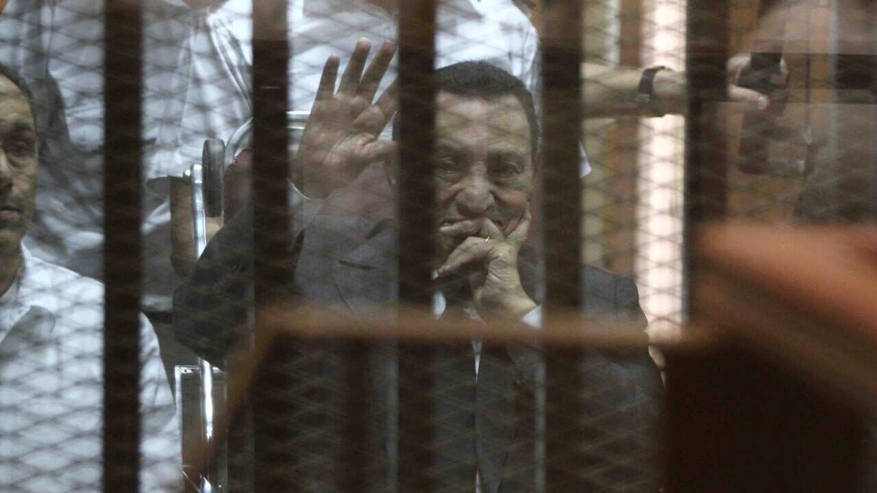 Egypt's deposed president Hosni Mubarak waves from behind the accused cage during his trial on May 21, 2014 in Cairo. (HASSAN MOHAMED/AFP/Getty Images)