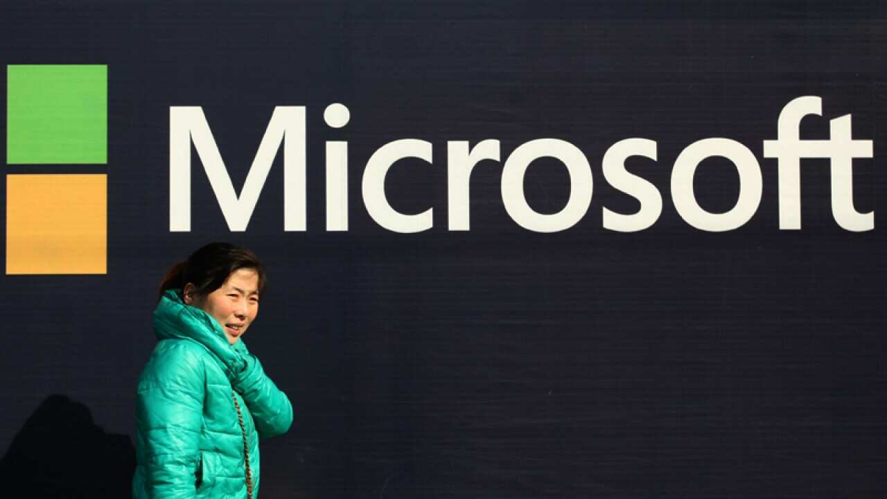 A pedestrian walks past an advertisement for Microsoft in Shanghai