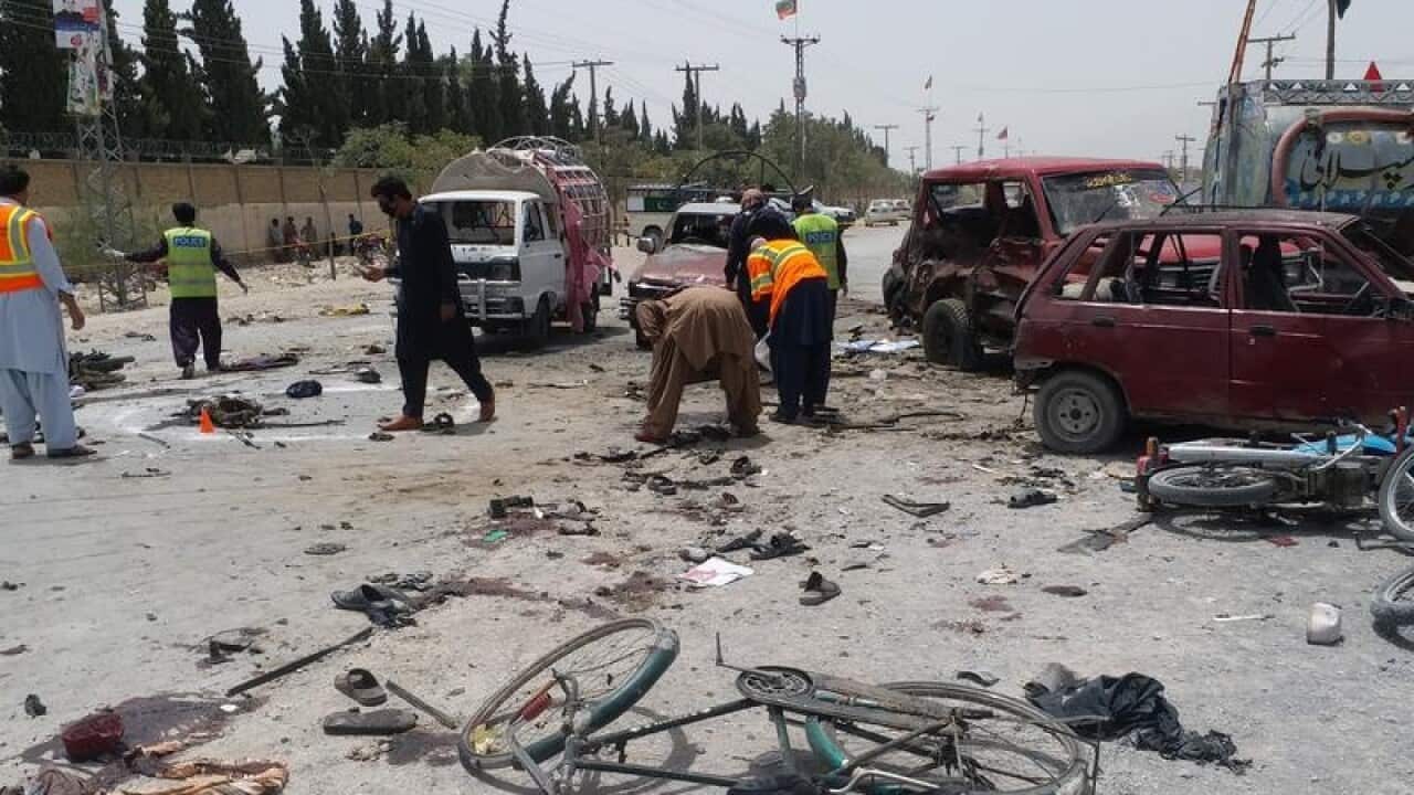 Pakistani security officials inspect the scene of a bomb attack.