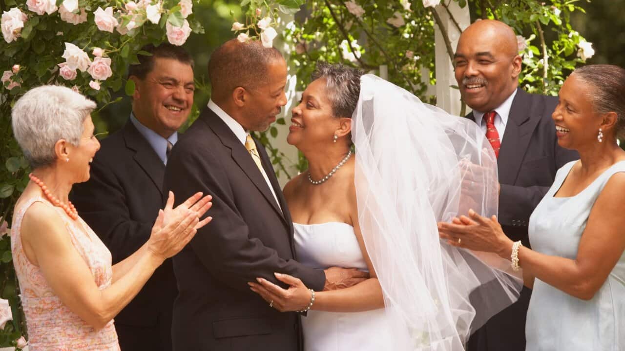 Middle-aged African bride and groom hugging
