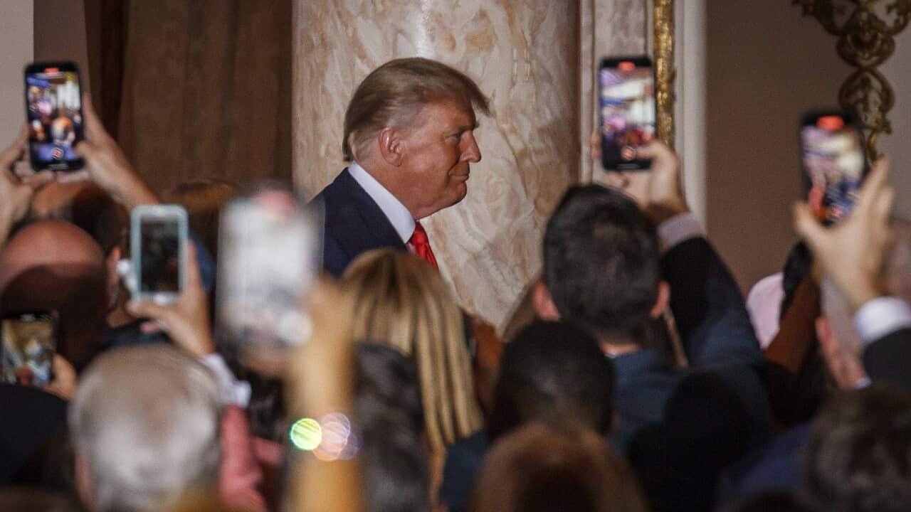 Donald Trump at the front of a crowded room